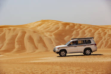 Tourist driving in desrt in off-road vehicle, Wahiba Sands, Oman - WWF05291