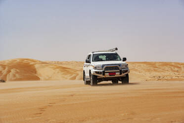 Tourist driving in desrt in off-road vehicle, Wahiba Sands, Oman - WWF05292
