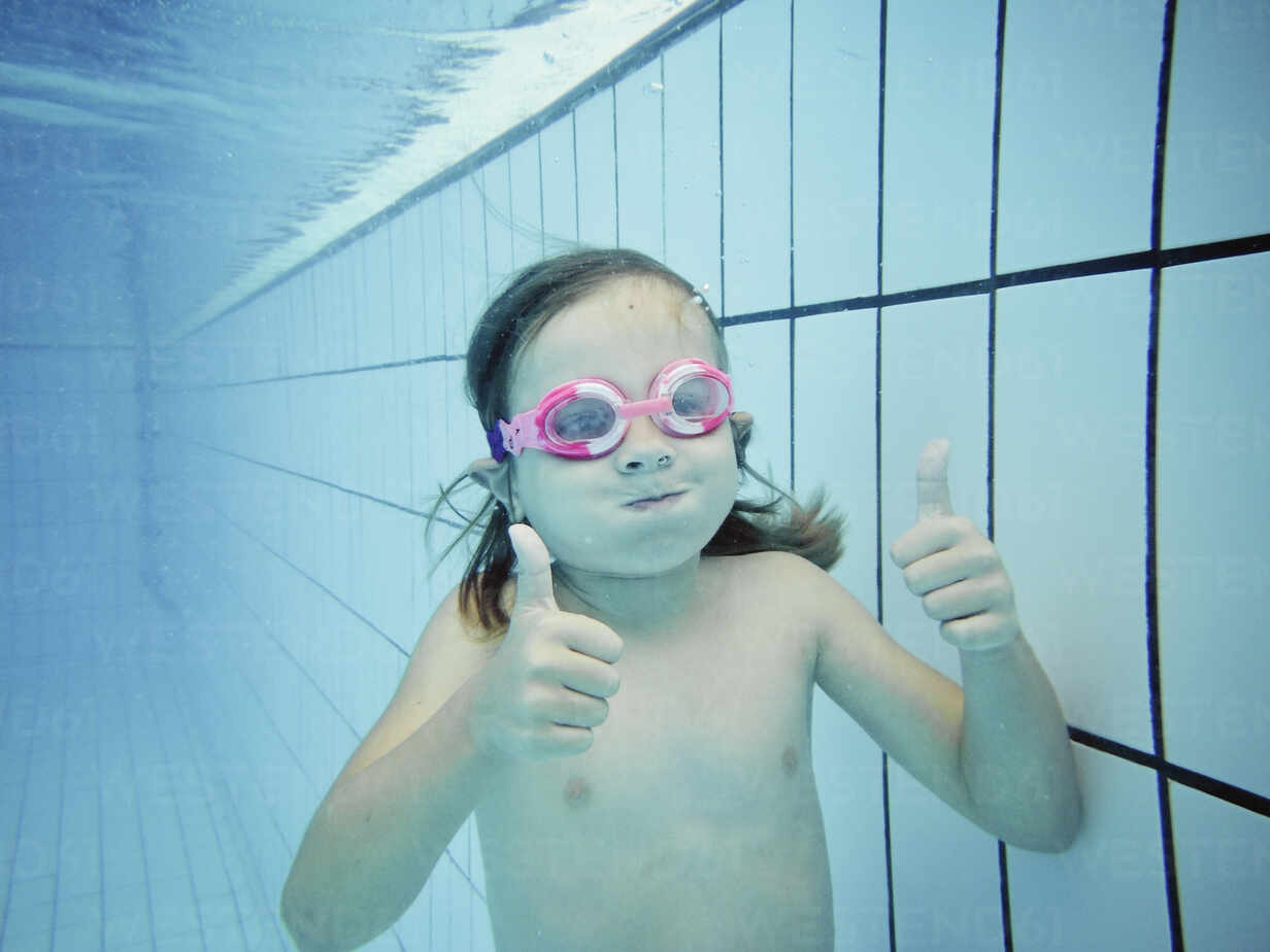 Underwater portrait of a girl with thumbs up stock photo