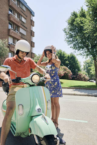 Junges Paar steht an einem Oldtimer-Roller, lizenzfreies Stockfoto