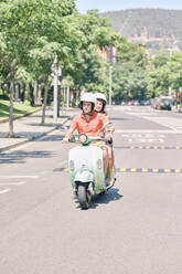 Young couple riding vintage motor scooter on urban road - JNDF00120