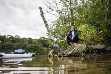 Businessman at lakeshore looking out - JOSF03791