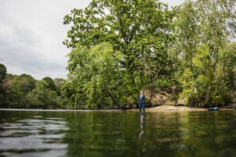 Geschäftsmann auf einer einsamen Insel in einem See, lizenzfreies Stockfoto