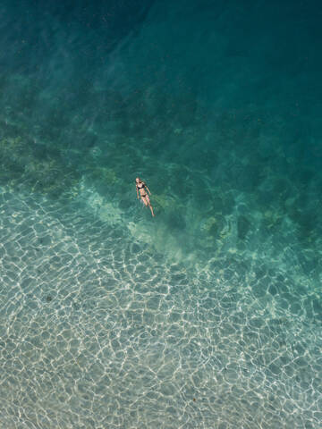 Frau schwimmt im Meer, Gili Air, Gili-Inseln, Indonesien, lizenzfreies Stockfoto