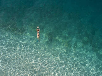 Woman floating in the sea, Gili Air, Gili Islands, Indonesia - KNTF03595