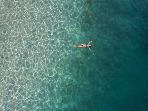 Frau schwimmt im Meer, Gili Air, Gili-Inseln, Indonesien, lizenzfreies Stockfoto