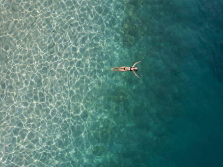 Woman floating in the sea, Gili Air, Gili Islands, Indonesia - KNTF03597
