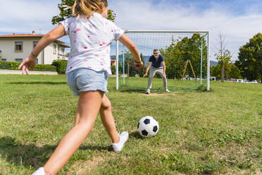 Vater und Tochter spielen Fußball auf einer Wiese - MGIF00735
