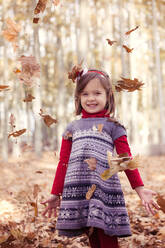 Lächelndes Mädchen im Herbstwald stehend - XCF00259