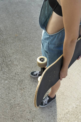 Junge Frau mit Skateboard, Nahaufnahme, lizenzfreies Stockfoto
