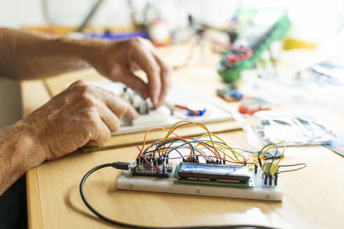 Ein älterer Mann arbeitet an elektronischen Schaltkreisen in seiner Werkstatt - AFVF04012