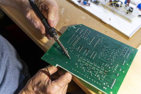 Senior man working on electronic circuits in his workshop, close up stock photo