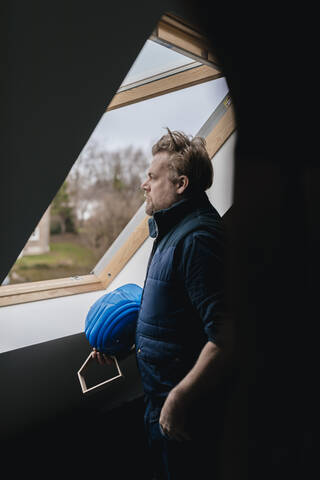 Architekt schaut aus dem Fenster auf einer Baustelle, lizenzfreies Stockfoto