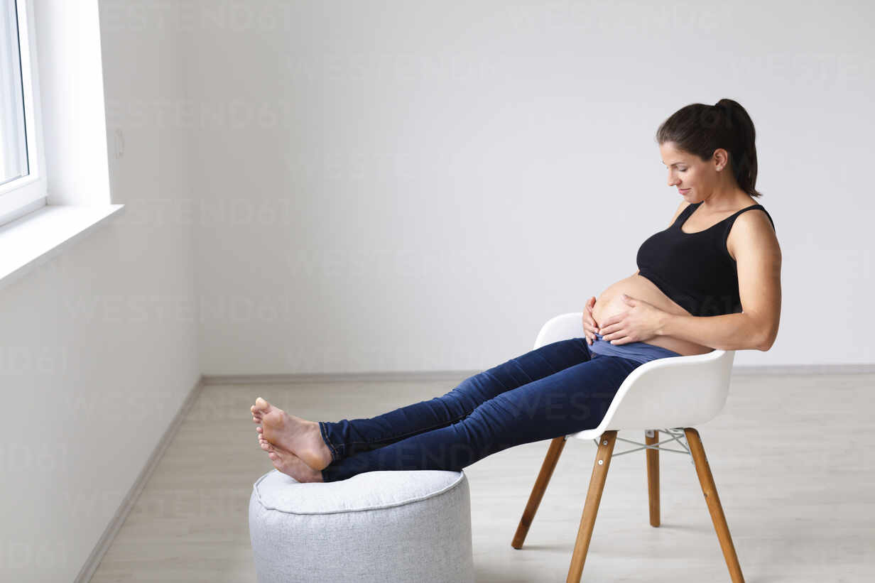 https://us.images.westend61.de/0001262578pw/young-pregnant-woman-sitting-on-chair-and-is-thinking-about-the-future-HMEF00599.jpg