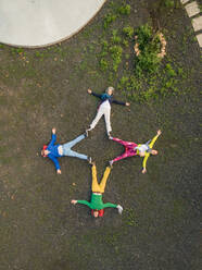 Luftaufnahme einer Familie, die mit ihren Körpern einen Stern auf Fuerteventura, Kanarische Inseln, zeichnet. - AAEF03640