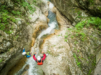 Aerial view two men canyoning. - AAEF03668