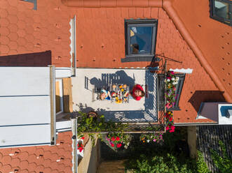 Aerial view of mother and son having breakfast on rooftop balcony. - AAEF03678