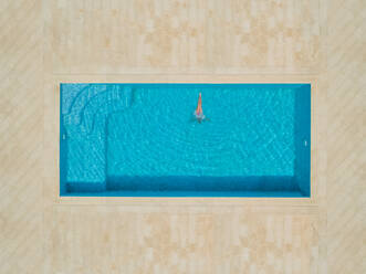 Luftaufnahme eines Mädchens, das in ein Schwimmbecken springt, Sumartin, Kroatien. - AAEF03731