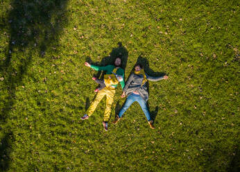 Aerial view of family laying down on grass at public playground, Zagreb. - AAEF03752