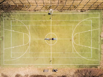 Aerial view of two people lying on a basket/ Tennis ground in Singapore - AAEF03785