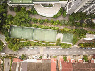 Luftaufnahme eines von Bäumen und Gebäuden umgebenen Tennisplatzes in Singapur - AAEF03805