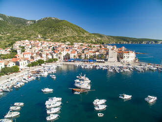 Luftaufnahme der Stadt Komiza und der im Yachthafen angedockten Boote auf der Insel Vis, Kroatien. - AAEF03910