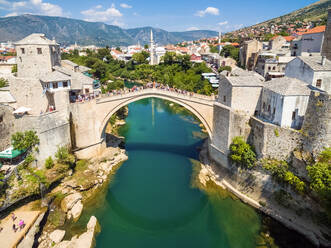 Aerial view of people crossing Old Bridge over Neretva river in Mostar, Bosnia and Herzegovina. - AAEF03931