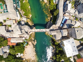 Aerial view of people crossing Old Bridge over Neretva river in Mostar, Bosnia and Herzegovina. - AAEF03934