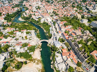 Aerial view of city of Mostar in Bosnia and Herzegovina and it's landmarks (Neretva river, Old bridge, Koski Mehmed Pasha Mosque). - AAEF03936