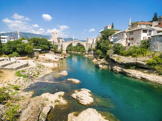 People at Old Bridge over Neretva river in Mostar, Bosnia and Herzegovina. - AAEF03938