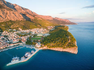 Luftaufnahme von Makarska bei Sonnenuntergang mit dem Berg Biokovo im Hintergrund (Kroatien). - AAEF03945