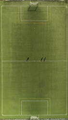 Aerial view of a football training players and shadows on synthetic surface football pitch on a summer day. - AAEF04233