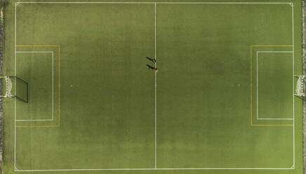 Aerial view of a two players training on synthetic surface football pitch on a summer day. - AAEF04235