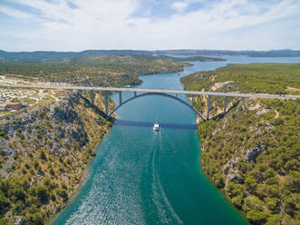 Autobahnbrücke über den Fluss Krka mit darunter fahrendem Boot, Kroatien. - AAEF04243
