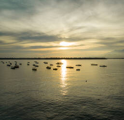 Luftaufnahme einer Gruppe von Booten, die während des Sonnenuntergangs neben der Insel Gili Trawangan vor Anker liegen. - AAEF04305