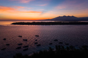 Luftaufnahme von Booten und Bergen bei Sonnenuntergang vor den Gili-Inseln, Indonesien. - AAEF04347