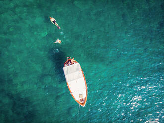 Luftaufnahme von Menschen, die von einem Boot aus im Tyrrhenischen Meer in der Nähe von Procida vor der Küste von Neapel in Süditalien schwimmen. - AAEF04361