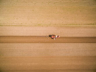 Aerial view of machinery seeding field for agriculture, Netherlands. - AAEF04453