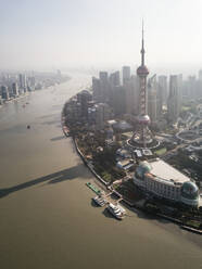 Aerial view of Shanghai skyline with Oriental Pearl Tower in foreground with passing Huangpu river, China. - AAEF04460