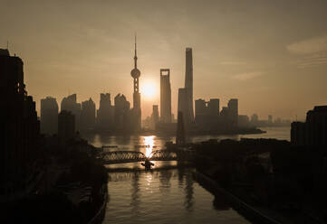 Aerial view of Shanghai skyline at sunset with passing Huangpu river, China. - AAEF04462