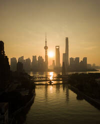 Luftaufnahme der Skyline von Shanghai bei Sonnenuntergang mit vorbeifließendem Huangpu-Fluss, China. - AAEF04463