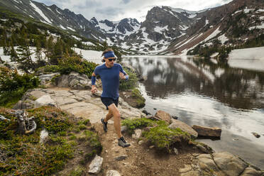 Mann läuft am Seeufer in der Indian Peaks Wilderness, Colorado - CAVF63404