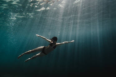 Frau schwimmt in voller Länge unter Wasser im Ozean - CAVF63537