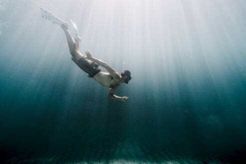 Mann schwimmt in voller Länge unter Wasser im Ozean - CAVF63547