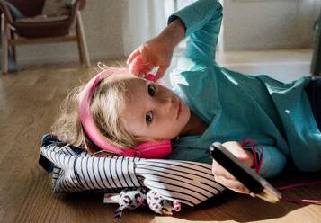 Portrait of a young girl listening to music at home - CAVF63672