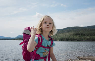 Porträt eines jungen Mädchens beim Wandern mit einem Rucksack am Meer - CAVF63873