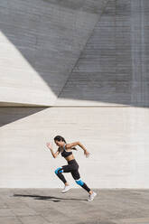 Female athlete running on concrete vertical - CAVF63986