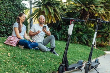 Couple with Scooters and Cell Phone - CAVF64071