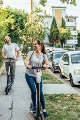 Woman and Man Ride Scooters - CAVF64076