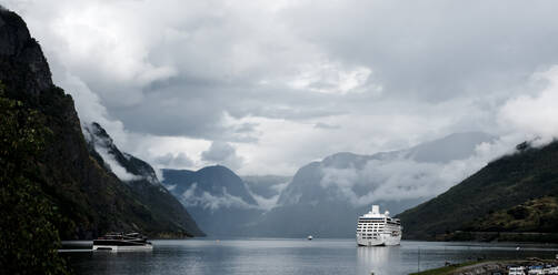 Kreuzfahrtschiff fährt durch den Nebel in einem atemberaubenden Fjord in Norwegen - CAVF64095